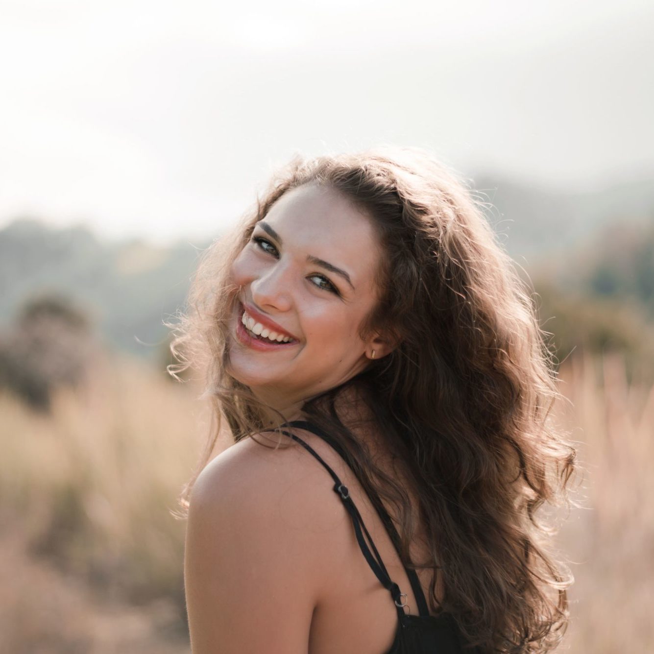 Woman happy with her smile after visiting Hughes Dental